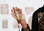 Dłoń kobiety trzymająca symbol religijny