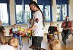Mężczyzna uczy dzieci grać na gitarze