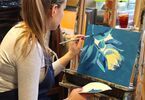Uczestniczka warsztatów podczas tworzenia swojego obrazu malowanego akrylem
