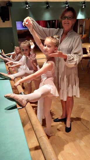 Krystyna Goliasz poprawia figurę młodej tancerki ćwiczącej przy drążku