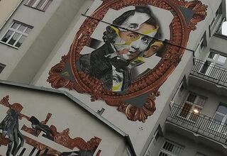 Zdjęcie muralu z wizerunkiem Fryderyka Chopina w złotych ramach.