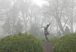 Pomnik taczącej kobiety w parku.