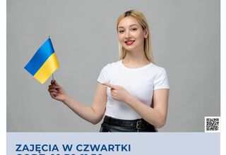 Dziewczyna w białej bluzce trzymająca w prawej ręce małą flagę Ukrainy