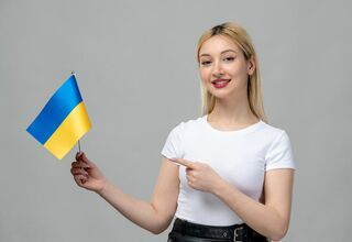 Kobieta trzyma w ręku ukraińską flagę