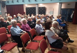 Zdjęcie seniorów siedzących na krzesłach