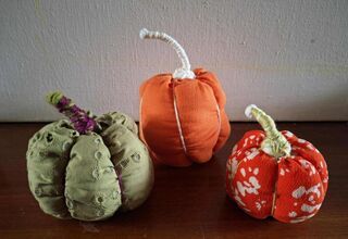 Zdjęcie: trzy kolorowe dynie na drewnianym blacie