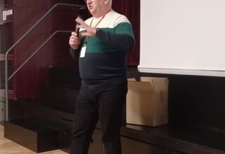 Zdjęcie starszego mężczyzny w biało-zielono-niebieskim swetrze