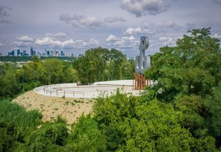 Zdjęcie kopca porośniętego trawą , na platformie widokowej  symbol Polski Walczącej, foto:https://zzw.waw.pl/nasze-tereny/parki/park-akcji-burza/