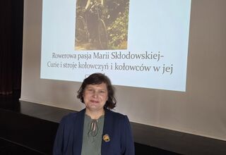 Zdjęcie kobiety w średnim wieku na tle prezentacji z wykładu