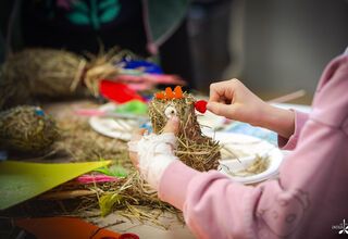 Zdjęcie: dziecięce ręce podczas formowania kury z siana