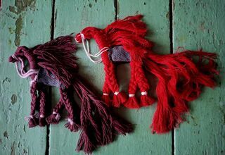 Zdjęcie: Dwie prace wykonane ze sznurka w czerwonym i bordowym kolorze na drewnianych deskach w pistacjowym kolorze