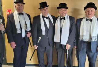 Zdjęcie starszych panów w garniturach, kapeluszach i białych szalikach