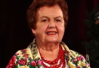 Zdjęcie kobiety w wieku senioralnym, w czerwonych koralach i kolorowej chuście