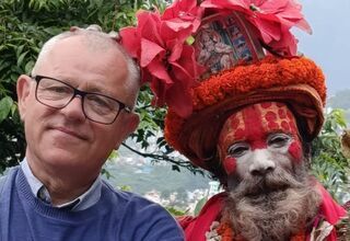 Portret mężczyzny w okularach w towarzystwie mężczyzny z wymalowaną na czerwono twarzą