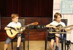 Chłopcy podczas nauki gry na gitarze