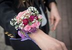 Zbliżenie na ręce kobiety z bukiecikiem kwiatów na nadgarstku