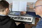 Mężczyzna uczy chłopaka gry na keyboardzie
