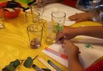 Dzieci prowadzą eksperyment ze szklankami i papierowymi próbnikami
