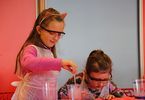 Dziewczynki w chronnych okularach prowadzą eksperyment