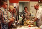 Kucharz pokazuje kobietom i mężczyźnie jak kroić ziemniaki na frytki