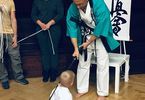 Mężczyzna w stroju do karate pasuje chłopczyka na ucznia