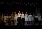 Grupa dzieci i nastolatków śpiewa na scenie
