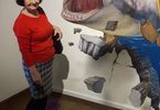 Kobieta pozuje na tle muralu rekina