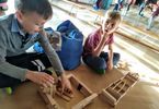 Dzieci tworzą konstrukcję z drewnianych klocków