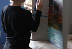 Chłopczyk maluje obraz na kartonie