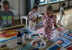 Dzieci stoją przy namalowanych obrazach