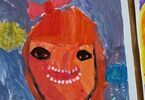 Namalowany przez dziecko portret uśmiechniętej dziewczynki