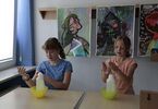 Dwie dziewczynki wykonują eksperyment przy użyciu miski i butelki
