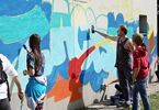Nastolatkowie i mężczyzna malują graffiti