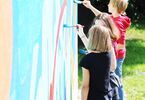 Trójka dzieci maluje graffiti na ścianie