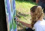 Dziewczyna maluje sprayem literę na kartonie