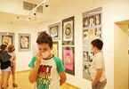 Grupa dzieci uczestniczy w wystawie prac artystycznych
