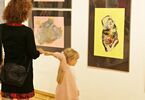 Kobieta z dziewczynką oglądają wystawę obrazów