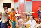 Dzieci przyglądają się eskperymentowi z wiatrakiem i plastikową tubą