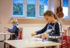 Dzieci przy stolikach prowadzą eksperyment