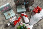 Prezenty ozdobione papierem ze świątecznym motywem oraz kokardami