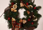 Wianek bożonarodzeniowy ozdobiony suszonymi owocami, pierniczkami, laskami cynamonu, szyszkami oraz kokardą