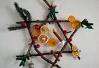 Gwiazda betlejemska wykonana z drewnianych patyczków, suszonych owoców i sztucznych świątecznych ozdób