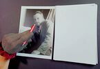 Ręka odziana w srebrną rękawiczkę wskazuje czerwonym długopisem na portret Paula Klee
