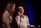 Dwie dziewczynki śpiewające w duecie do jednego mikrofonu.
