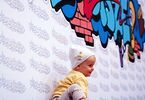 Małe dziecko w czapce na tle baneru na napisem Zacisze.