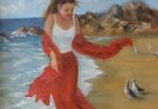 Młoda kobieta w czerwonej sukience spaceruje brzegiem morza