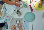 Stół z materiałami artystycznymi i pracami tworzonymi przez dzieci