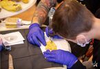 Uczestnik wykonuje tatuaż na skórce banana