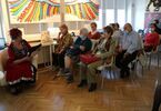 Seniorzy siedzą i słuchają