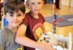 Chłopcy trzymający budowlę z klocków Lego
